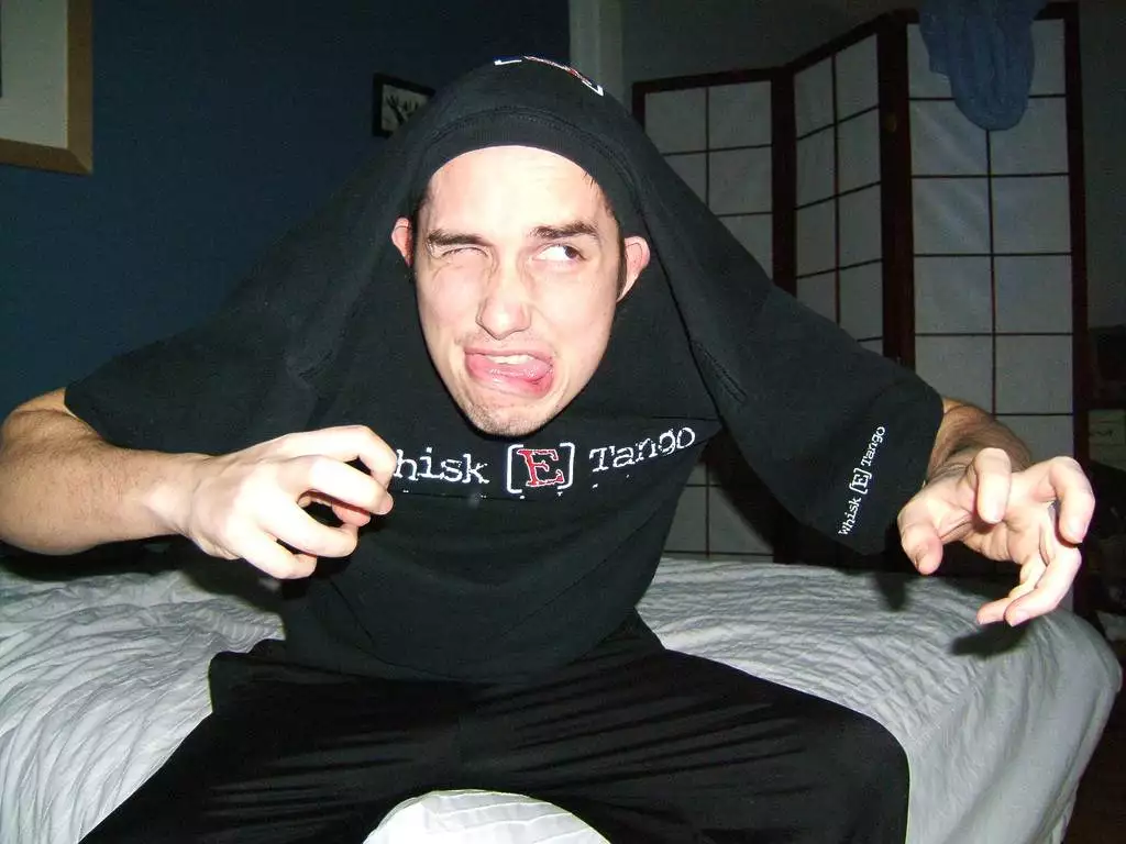 Mann mit schwarzem T-Shirt über dem Kopf
